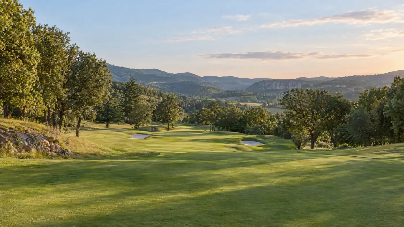 Illustration générée d’un fairway vallonné dans un paysage inspiré du nord de l’Ardèche ; elle ne représente pas un parcours précis.